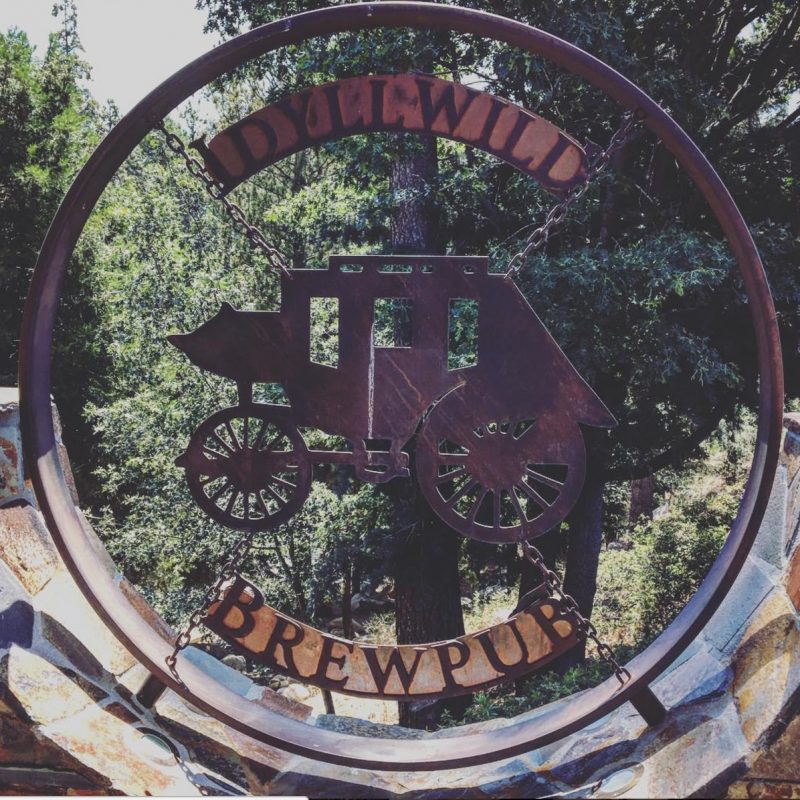 A sign showing a stagecoach at the entrance to the Idyllwild Brewpub